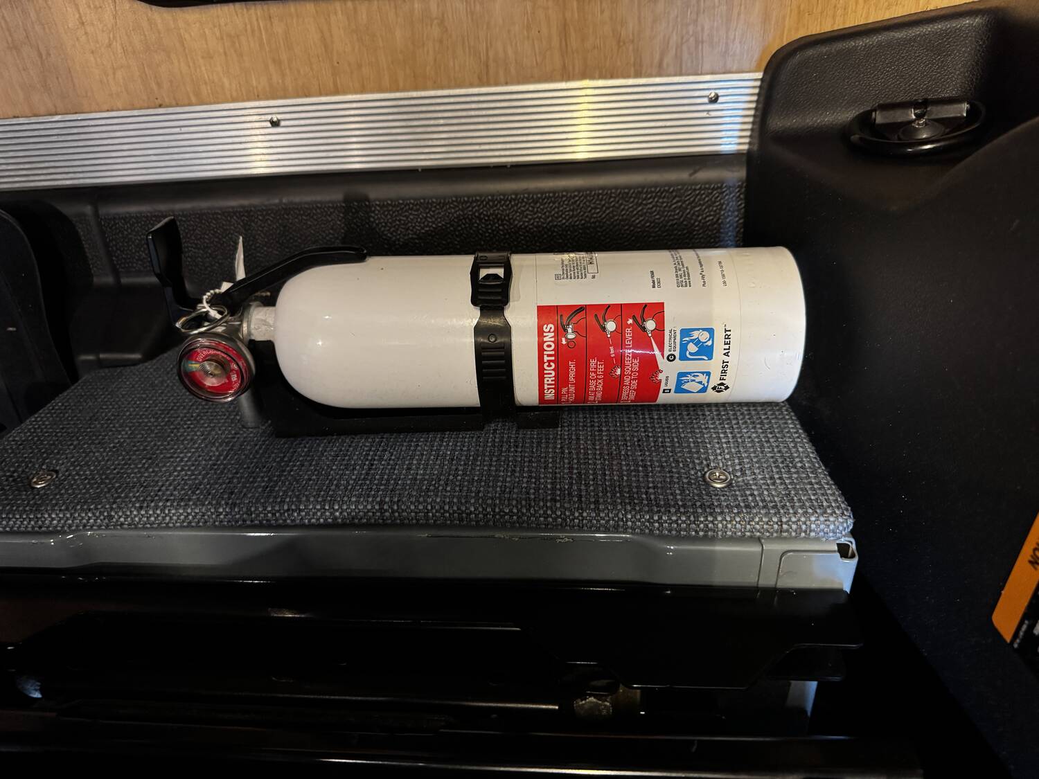 First Alert fire extinguisher mounted behind the driver seat