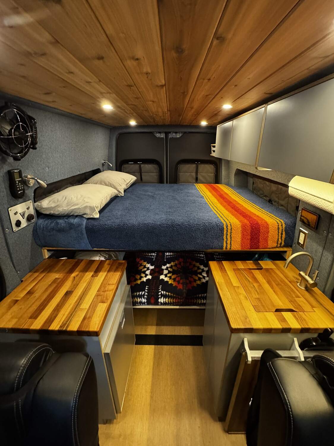 Cedar ceiling and walls with the bunk, blanket, and butcher-block counters