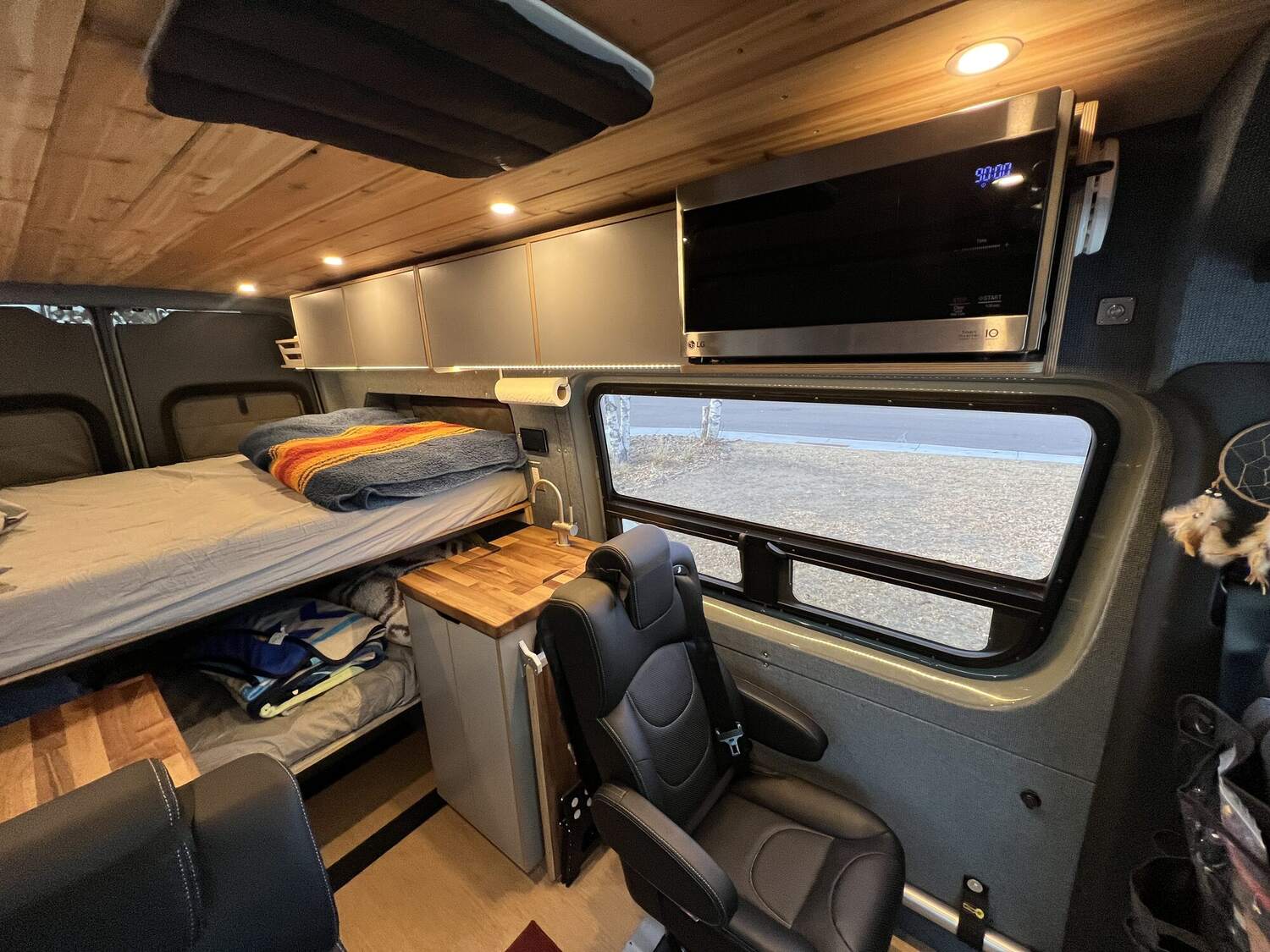 Galley with LG microwave, overhead cabinets, and large slider window
