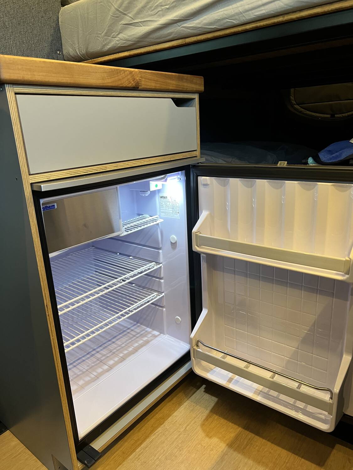 Isotherm 12V refrigerator open showing wire shelves and door bins