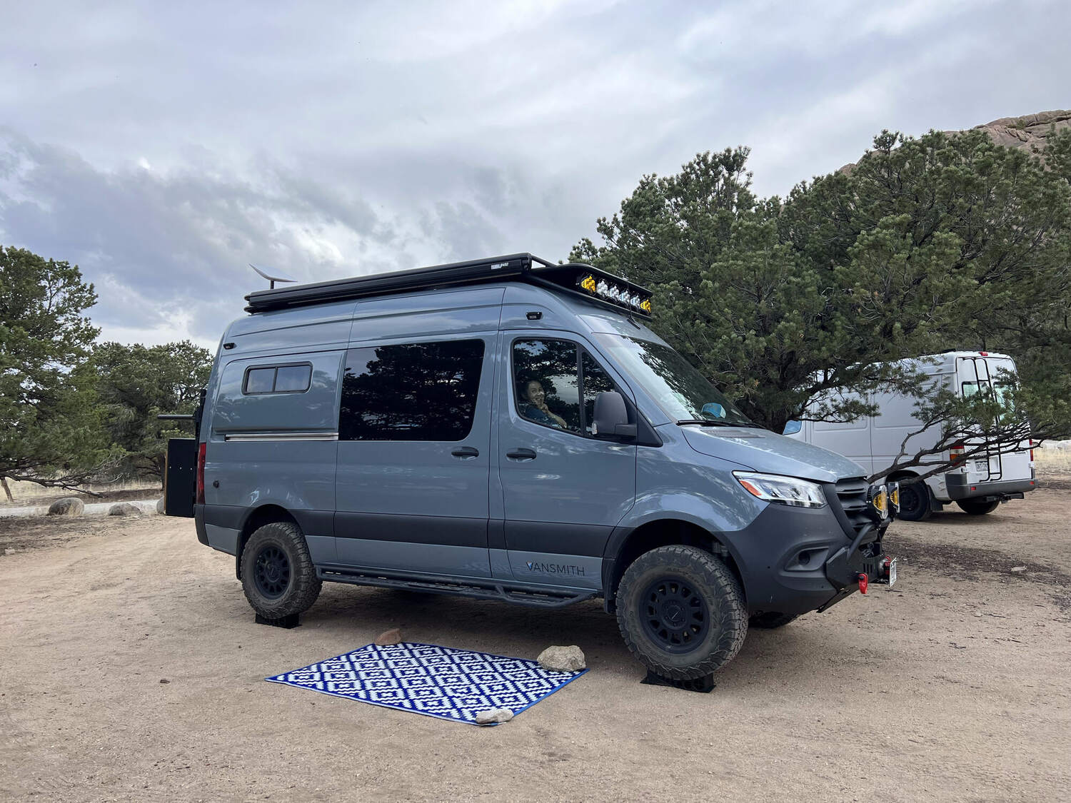 Sprinter set up at a Moab-area dispersed camp with outdoor rug