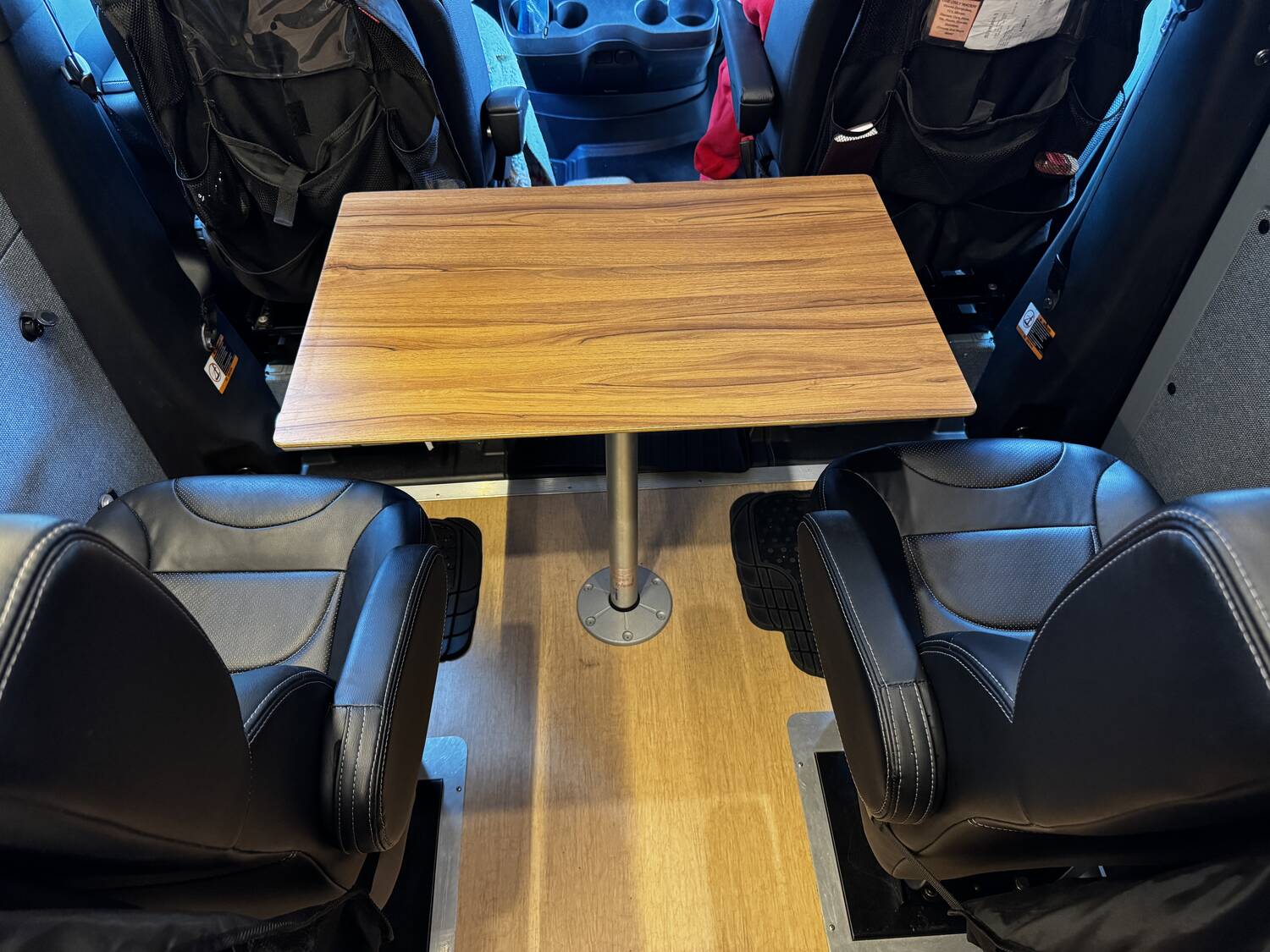 Post-mounted wood table between front swivel seats and 2nd-row JMG captain's chairs