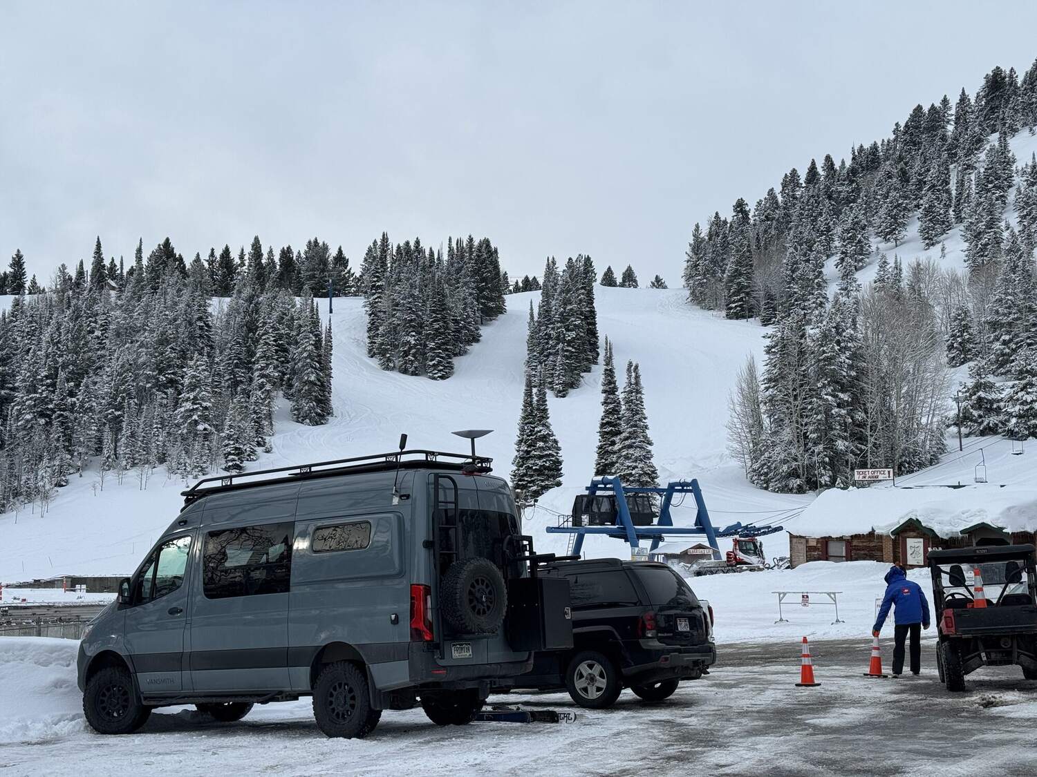 Sprinter parked at the base of a ski resort in fresh snow