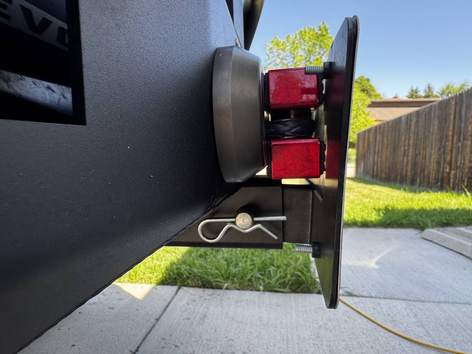 Quick-release license-plate bracket mounted to the rear bumper hitch tube